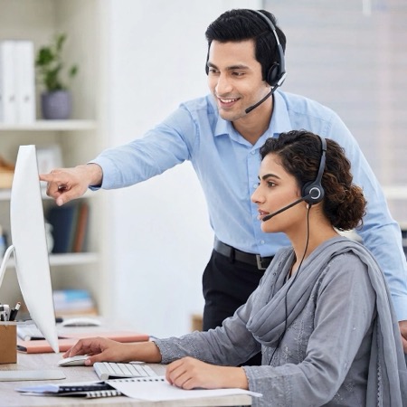 Two Zain Packages staff on headsets working through an order at a desk